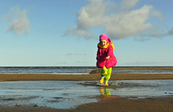 Little girl  on a sunset sandy autumn beach. — Stock Photo, Image