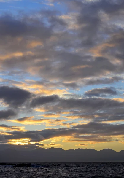 Nascer do sol no oceano com montanhas — Fotografia de Stock