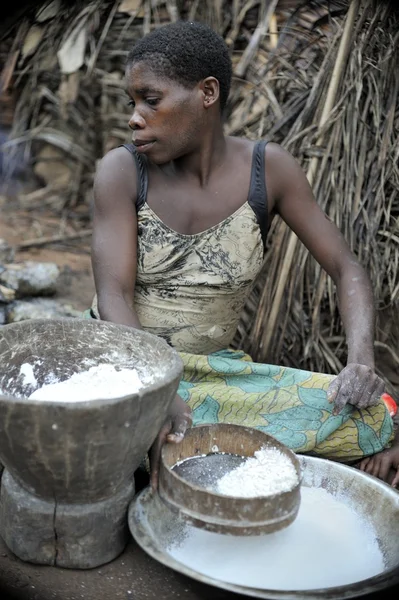 Baka femme cuisine de la nourriture, écrasant une farine dans un mortier — Photo