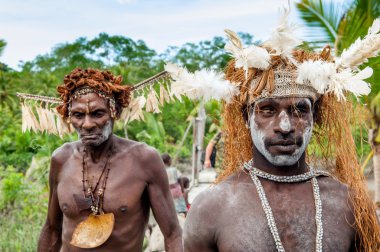 Asmats with a traditional painting on a face