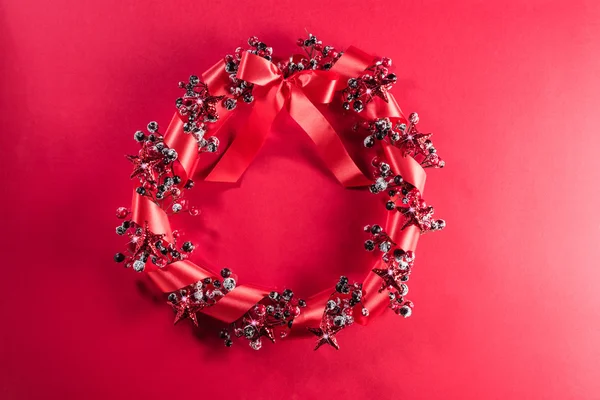 Corona de Navidad en rojo con cinta —  Fotos de Stock