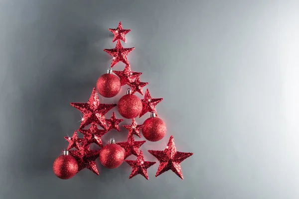 Weihnachtsbaumform mit roten Sternen und Kugeln — Stockfoto