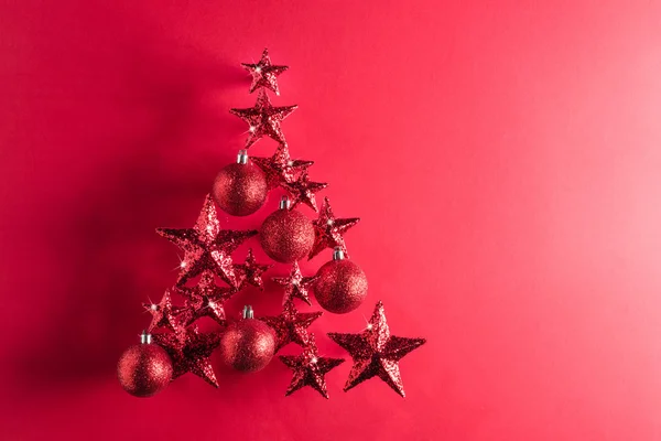 Julgran form med röda stjärnor och grannlåt — Stockfoto