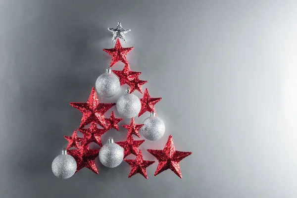 Forma de árvore de Natal com estrelas vermelhas e bugigangas de prata — Fotografia de Stock