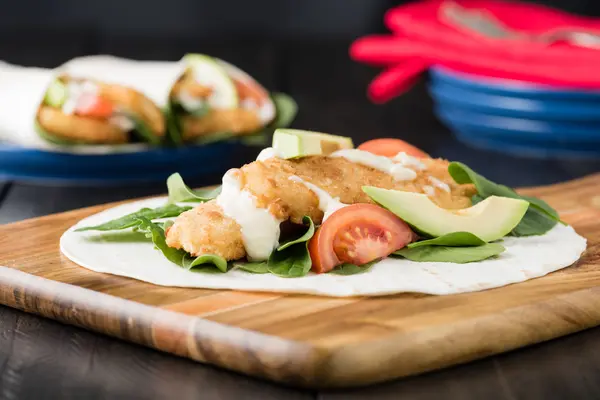 Burrito de filete de pescado desmenuzado con aguacate y tomate —  Fotos de Stock