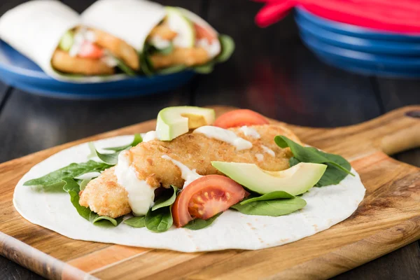 Crumbed fish fillet burrito with avocado and tomato — Stock Photo, Image