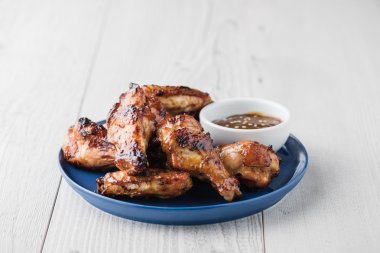 Teriyaki tavuk kanadı üzerinde beyaz masa üstü sos ile
