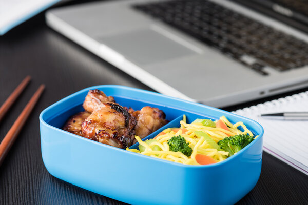 Домашний повар Бенто Бокс во время офисного обеда с ноутбуком
