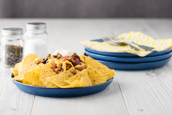 Rindfleisch-Nachos mit Jalapeño, Oliven, Tomaten, Bohnen Cheddar-Käse — Stockfoto