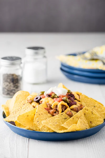 Rindfleisch-Nachos mit Jalapeño, Oliven, Tomaten, Bohnen Cheddar-Käse — Stockfoto