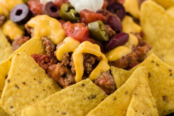 Rindfleisch-Nachos mit Jalapeño, Oliven, Tomaten, Bohnen Cheddar-Käse — Stockfoto
