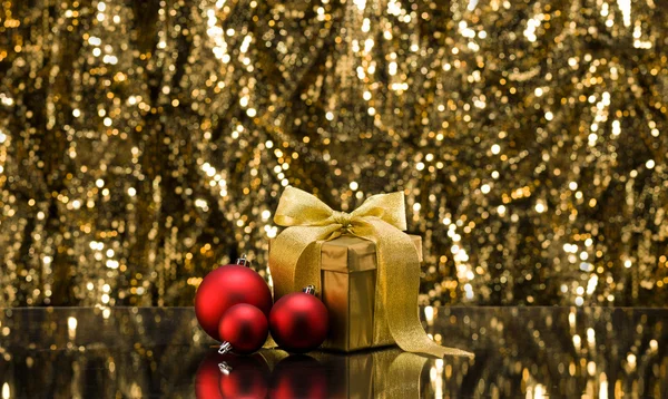 Gold present and Christmas tree baubles — Stock Photo, Image