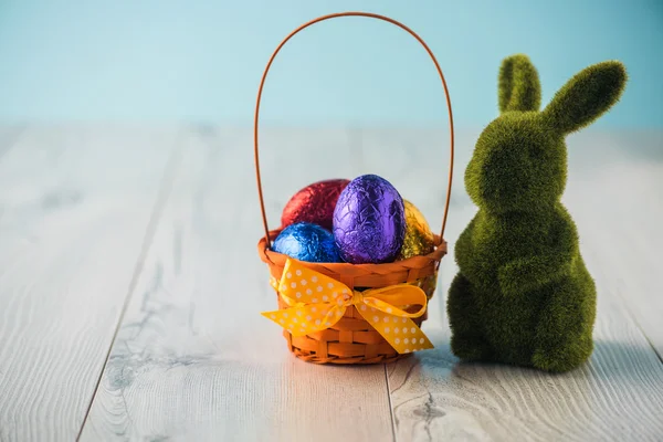 Easter eggs in a basket with a bunny — Stock Photo, Image
