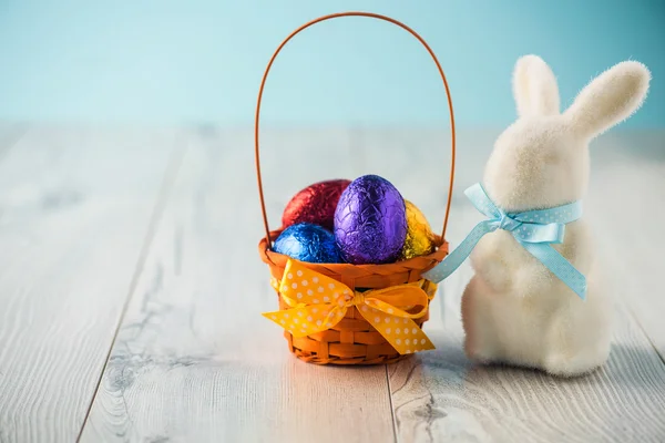 Easter eggs in a basket with a bunny — Stock Photo, Image