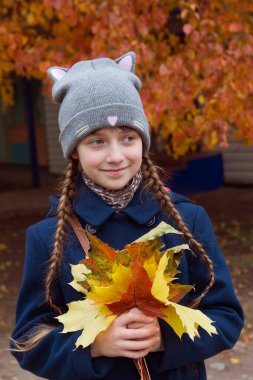 Küçük kız akçaağaç yapraklarını tut..