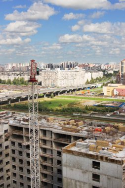 İnşaat binasının yanındaki gökdelenin yanındaki vinç.