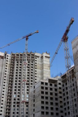 İnşaat binasının yanındaki gökdelenin yanındaki vinç.