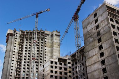 İnşaat binasının yanındaki gökdelenin yanındaki vinç.