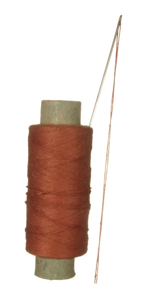 Spool of brown thread and needle isolated on white background. — Stock Photo, Image