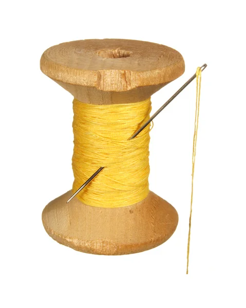 Old wooden spool of yellow thread and needle isolated on white b — Stock Photo, Image