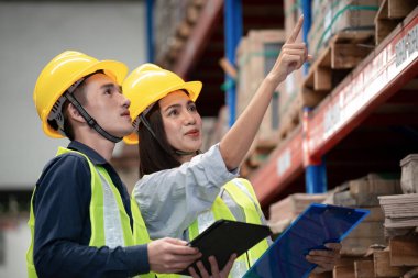 Depo çalışanı büyük bir mağazadaki paketlere bakıyor.