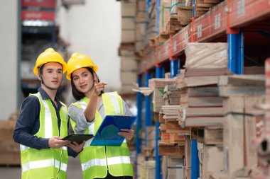 Depo çalışanı büyük bir mağazadaki paketlere bakıyor.