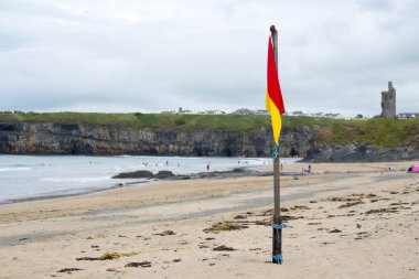red and yellow warning flag at beach clipart