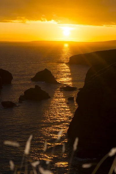 Puesta de sol sobre las rocas costeras con altibajos salvajes — Foto de Stock