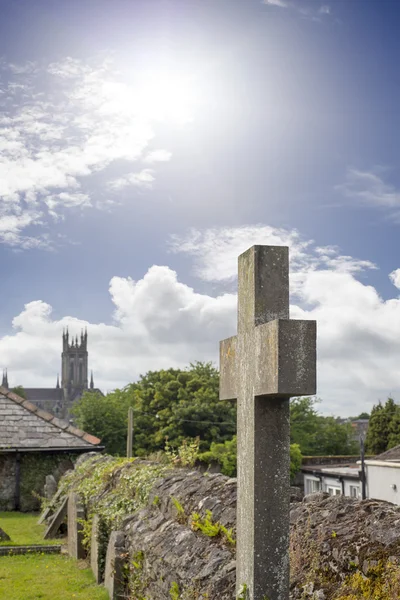 Sunshine over cross at ancient graveyard — Stock Photo, Image