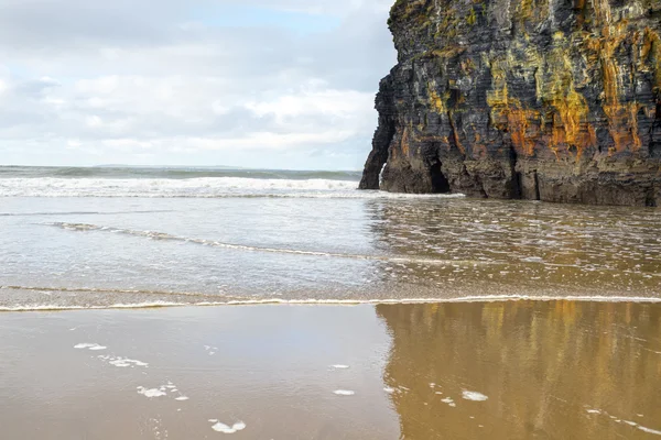 Areia molhada e reflexão penhasco — Fotografia de Stock