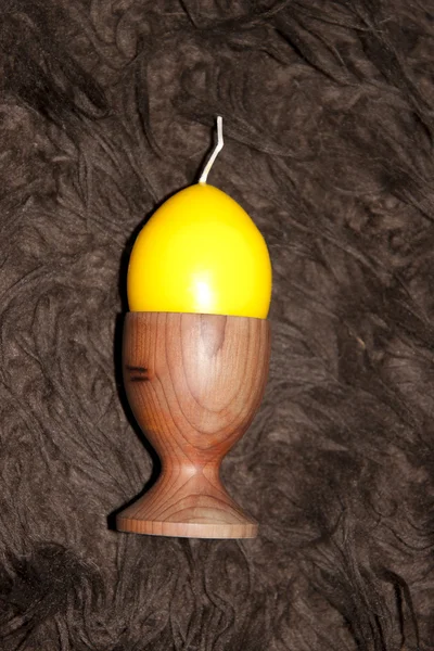 Vela em forma de ovo amarelo em uma xícara de ovo — Fotografia de Stock