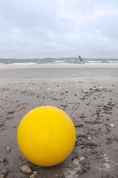Giant yellow buoy on beach — Stock Photo, Image