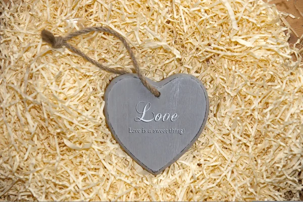Love heart in grey saying love is a sweet thing — Stock Photo, Image