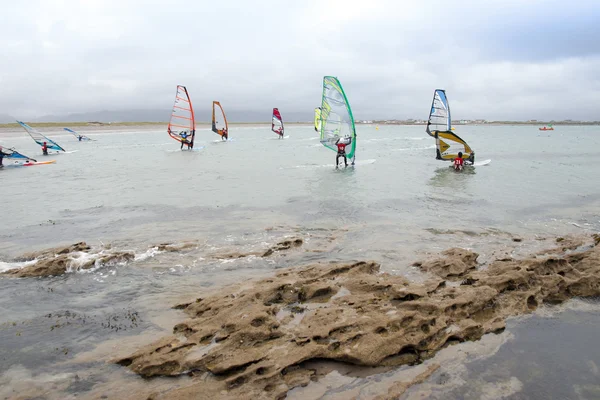 Les surfeurs bravant la forte tempête et les rochers — Photo