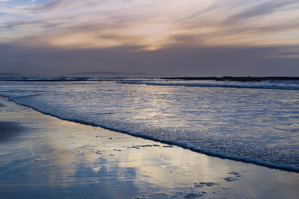 Reflektioner och lugna vågor kraschar på stranden — Stockfoto