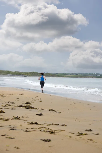 Young woman jogging on the beach — Stock Photo, Image