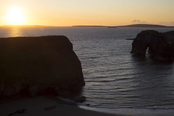 Puesta de sol sobre la playa de monjas y roca virgen — Foto de Stock