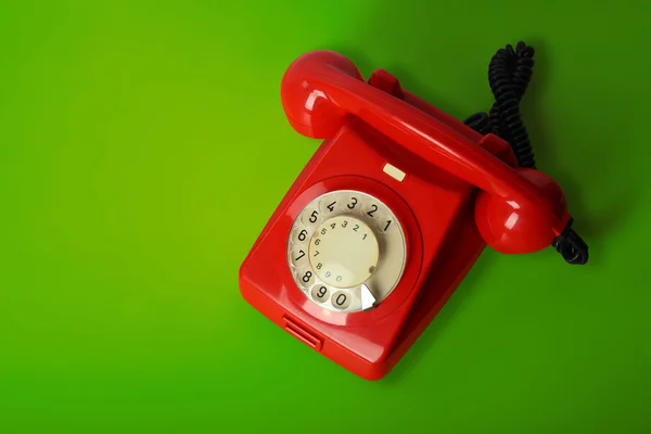 Yeşil bir arka plan üzerinde kırmızı vintage telefon — Stok fotoğraf