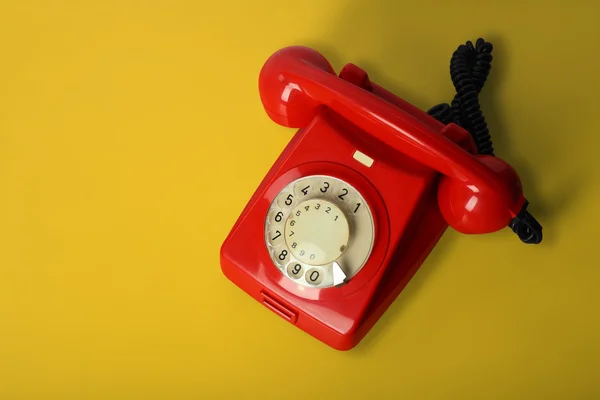 Telefone vintage vermelho em um fundo amarelo — Fotografia de Stock