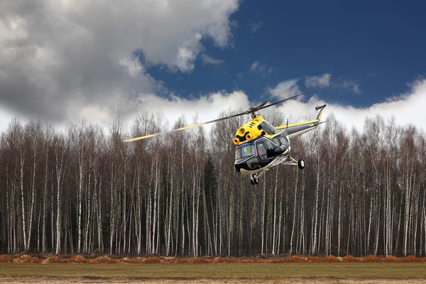 Aereo - Elicottero nero-giallo in volo a bassa altezza — Foto Stock