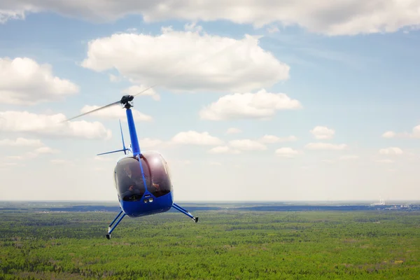 Das Flugzeug - der kleine blaue Helikopterflug vor dem wolkenverhangenen Himmel. — Stockbild Flugzeuge - Hubschrauberflug vor dem Hintergrund der Wolke — Stockfoto