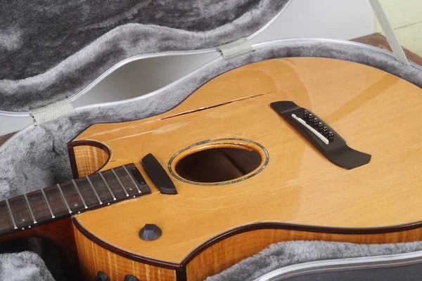 Musical instrument - Closeup fragment Broken acoustic guitar in hard case