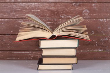 Bilim ve eğitim - Bir yığın kitap ve ahşap zemin üzerine açık kitap