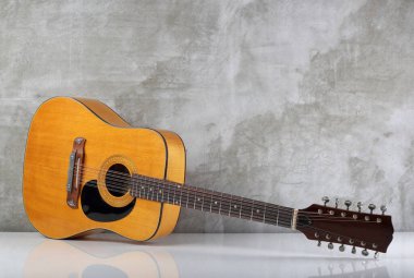 Müzikal enstrüman - Çok nadir bulunan 12 telli akustik gitar arka planda beton bir duvarın altında yansıması olan