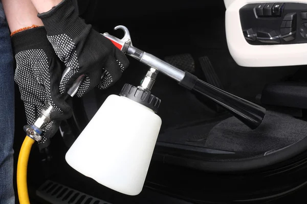 Car service. Worker washing of interior by a special cleaners — Stock Photo, Image