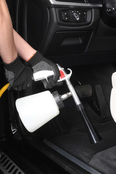 Car service. Worker washing of interior by a special cleaners — Stock Photo, Image