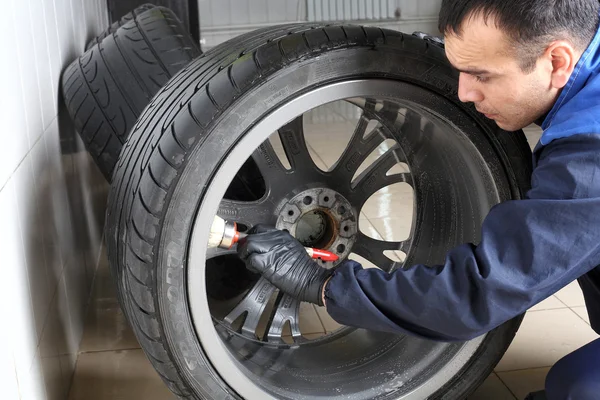 Car service. The worker washes rims