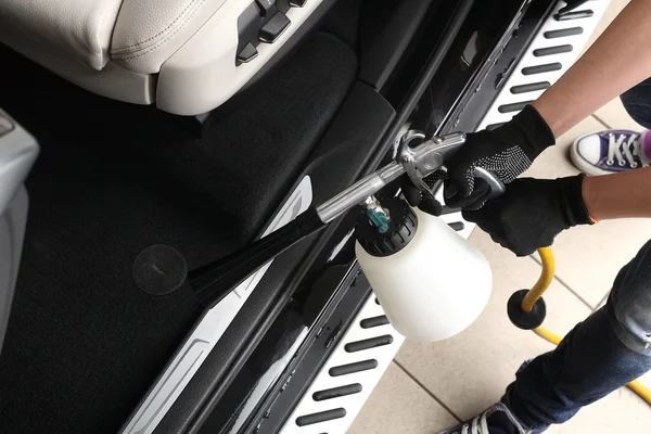 Car service. Worker washing of interior by a special cleaners — Stock Photo, Image