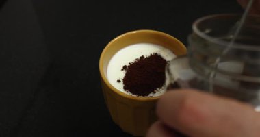 Kahvaltı için büyük turuncu bir fincanda sütlü ve esmer şekerli hazır kahve..