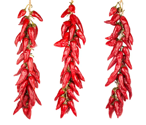 Chiles rojos picantes colgando de tres cuerdas Imagen De Stock